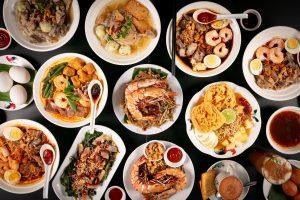Assorted gourmet Asian fusion dishes and seafood platters served on a black table.